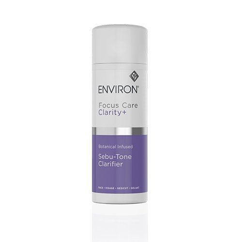 A white plastic bottle with a gray cap featuring the Environ logo and brand name. The text reads "Environ Focus Care Clarity+ Botanical Infused Sebu-Tone Clarifier" on a purple label. Designed for face cleaning, this lactic acid toner is perfect for oily skin and addressing acne problems.