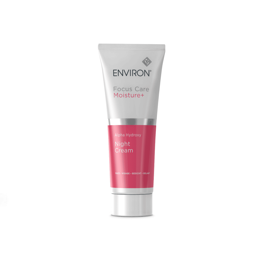 A white and pink tube of Environ Focus Care Moisture+ Alpha Hydroxy Night Cream by Environ. The tube, adorned with a silver cap, features text indicating the product, formulated with lactic acid, aims to exfoliate, hydrate, and revitalize the skin overnight.