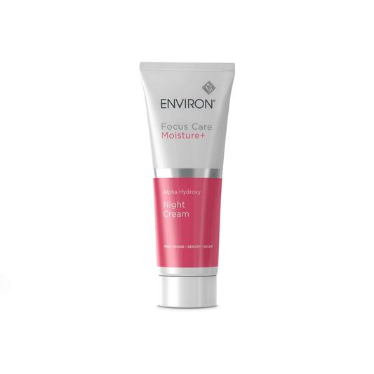 A white and pink tube of Environ Focus Care Moisture+ Alpha Hydroxy Night Cream by Environ. The tube, adorned with a silver cap, features text indicating the product, formulated with lactic acid, aims to exfoliate, hydrate, and revitalize the skin overnight.