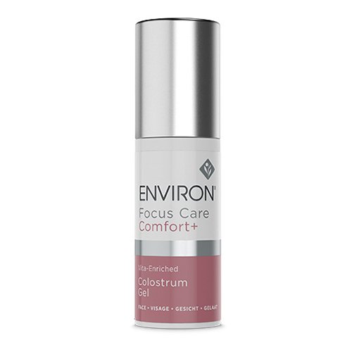 A cylindrical bottle of **Environ Focus Care Comfort+ Vita-Enriched Colostrum Gel** designed to boost skin immunity and support collagen production. The bottle features a metallic silver cap and a label with off-white and pink sections, proudly displaying the product name and details.